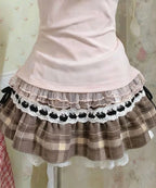Cárdigan de encaje + Top camisola + Minifalda a cuadros